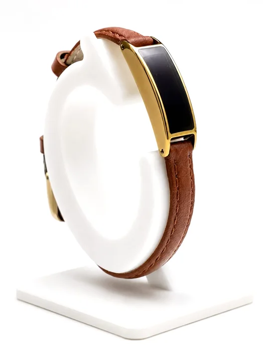 Ray in Sunlit Gold on a Cognac Leather band, on a display stand